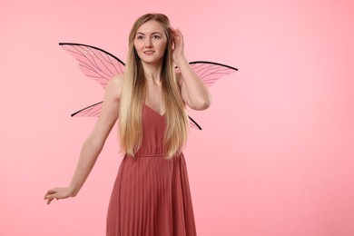 Beautiful girl in fairy costume with wings on pink background, space for text