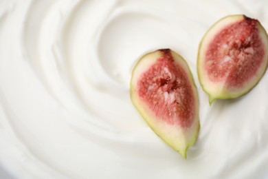 Tasty yogurt with cut fig as background, top view. Space for text