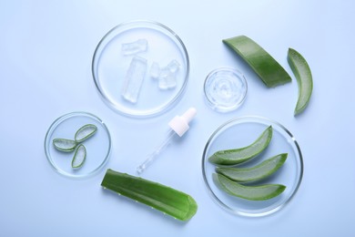 Photo of Flat lay composition with aloe vera leaves and cosmetic gel on light blue background