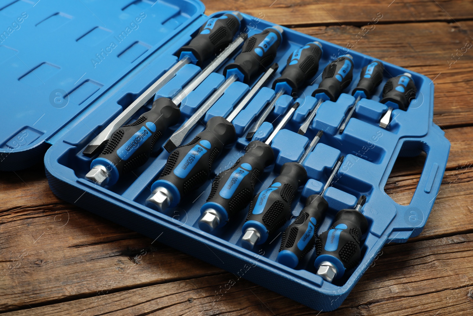 Photo of Set of screwdrivers in open toolbox on wooden table, closeup