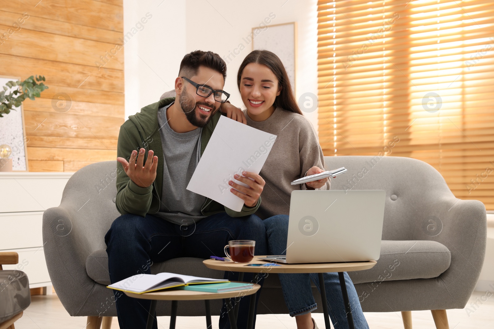 Photo of Young couple discussing family budget at home