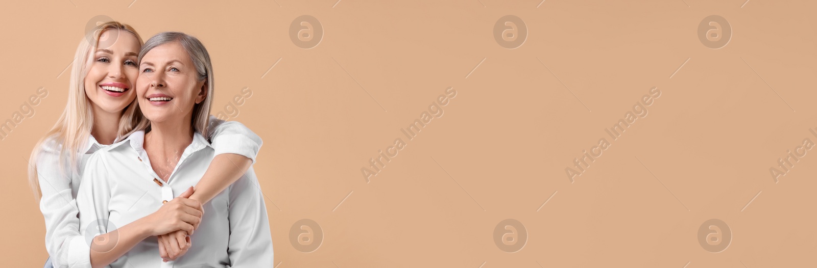 Image of Happy mother and daughter on beige background, space for text. Banner design