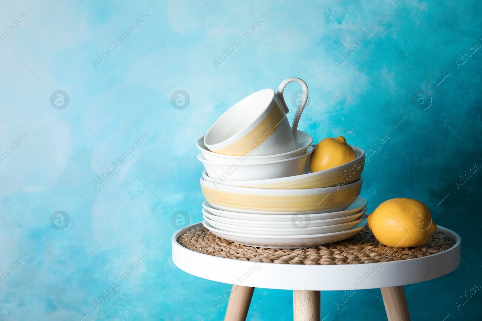 Photo of Composition with dinnerware on table against color background, space for text. Interior element