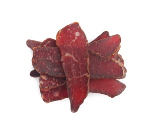 Photo of Pieces of delicious beef jerky on white background, top view