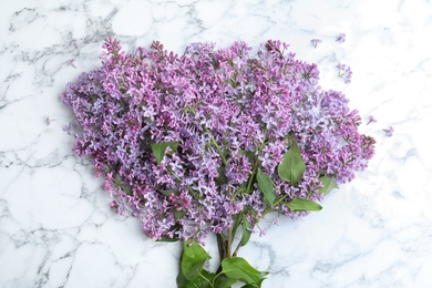 Photo of Blossoming lilac on marble table, top view. Spring flowers