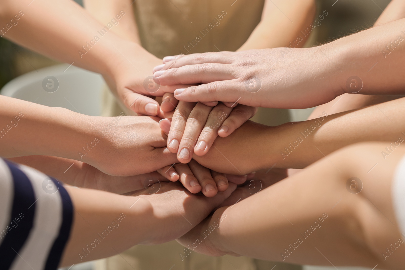 Photo of Group of people holding hands together indoors, closeup. Unity concept