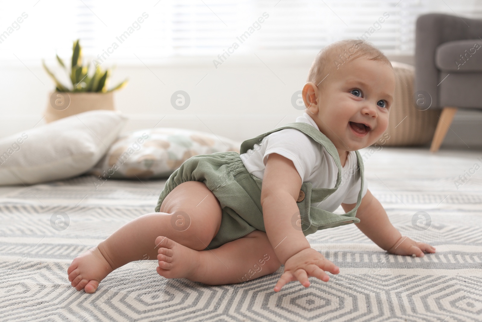 Photo of Cute baby crawling on floor at home