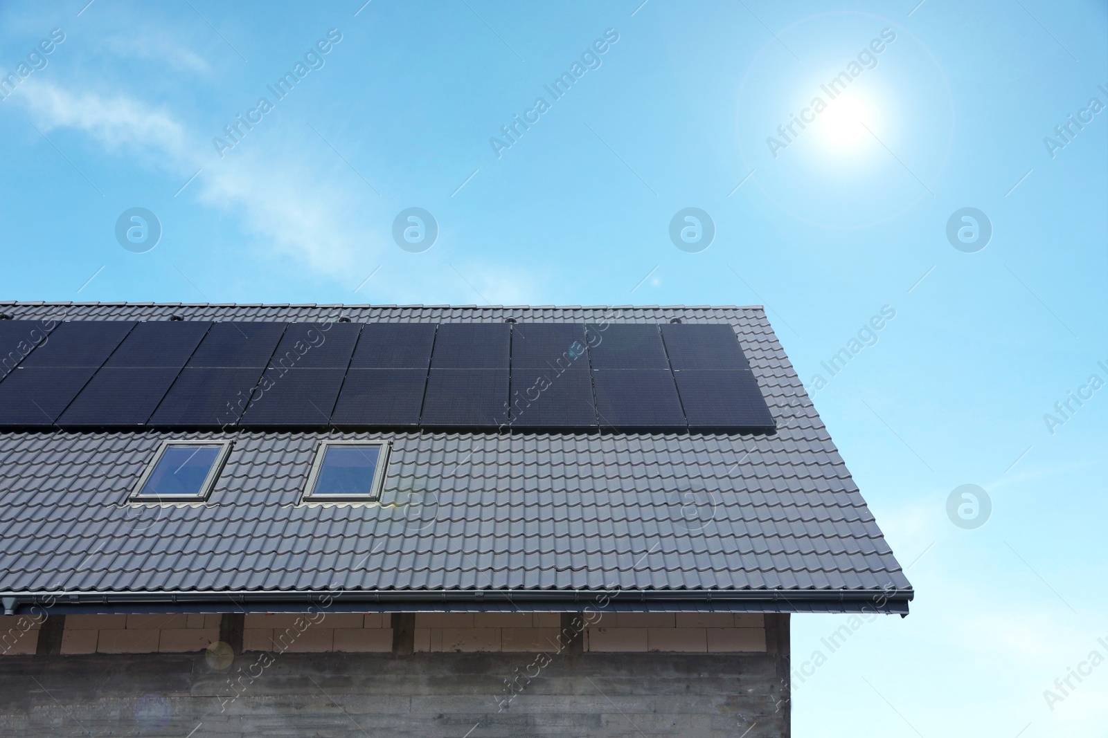 Photo of House with installed solar panels on roof. Alternative energy