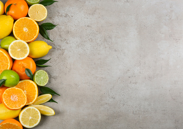 Photo of Flat lay composition with tangerines and different citrus fruits on grey background. Space for text