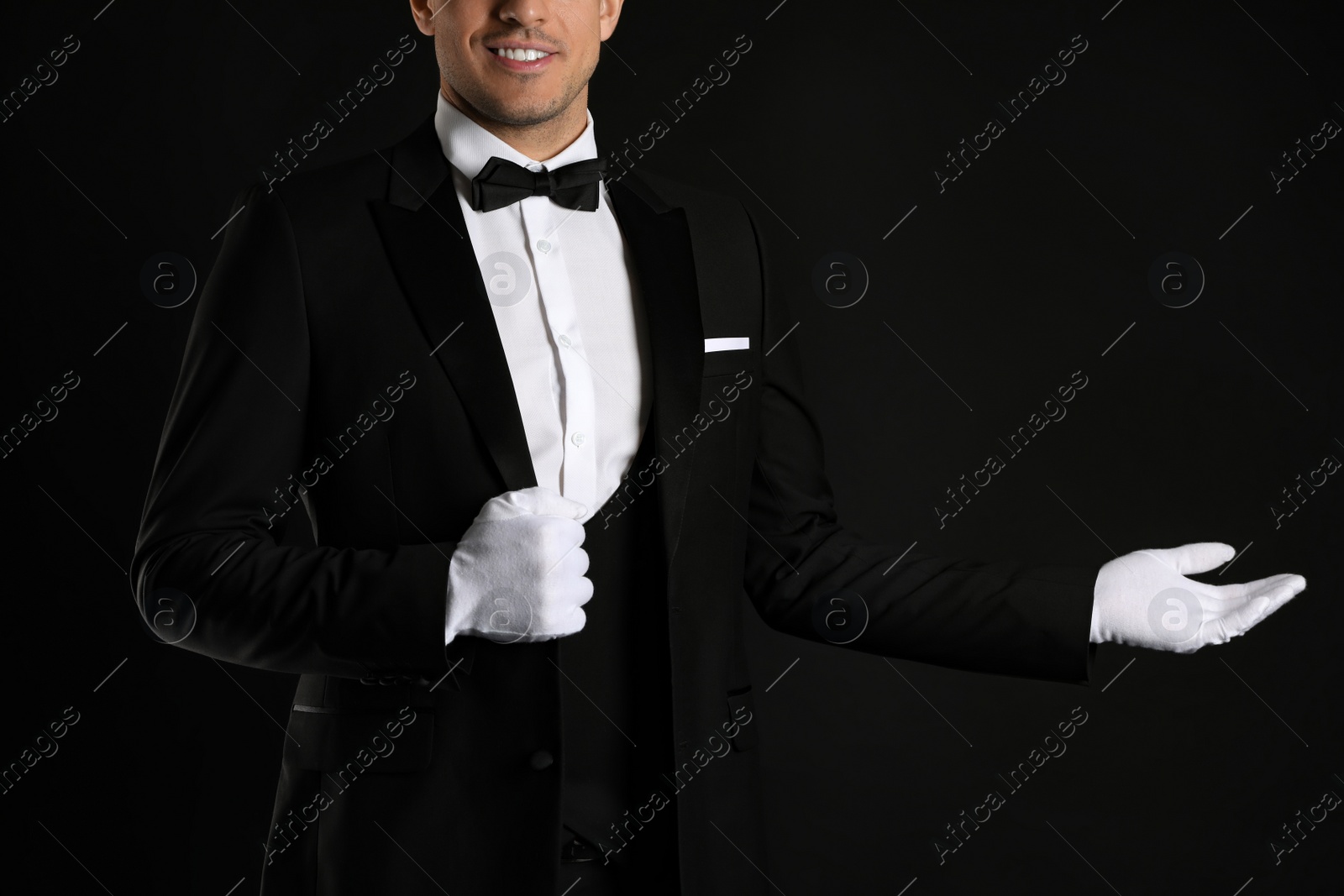 Photo of Butler in elegant uniform on black background, closeup