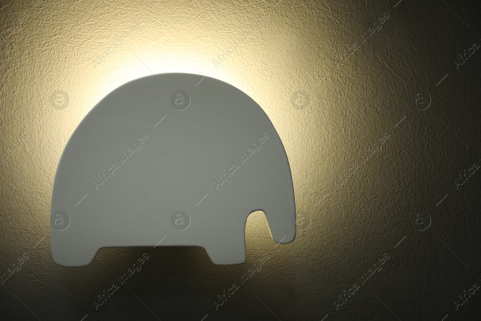 Photo of Animal shaped night lamp on wall. Space for text