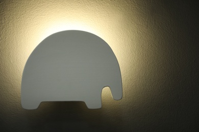 Photo of Animal shaped night lamp on wall. Space for text