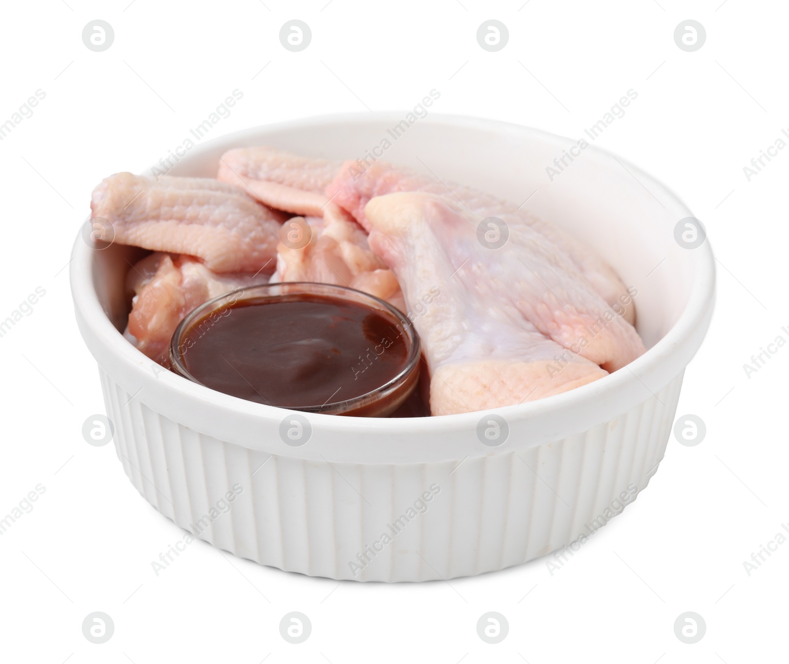 Photo of Fresh marinade and raw chicken wings in bowl isolated on white