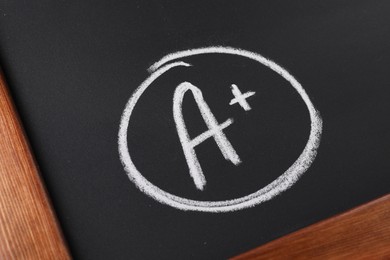 Photo of School grade. Letter A with plus symbol on blackboard, closeup