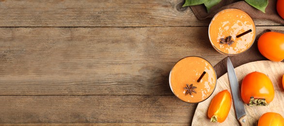 Tasty persimmon smoothie with anise and fresh fruits on wooden table, flat lay with space for text. Banner design