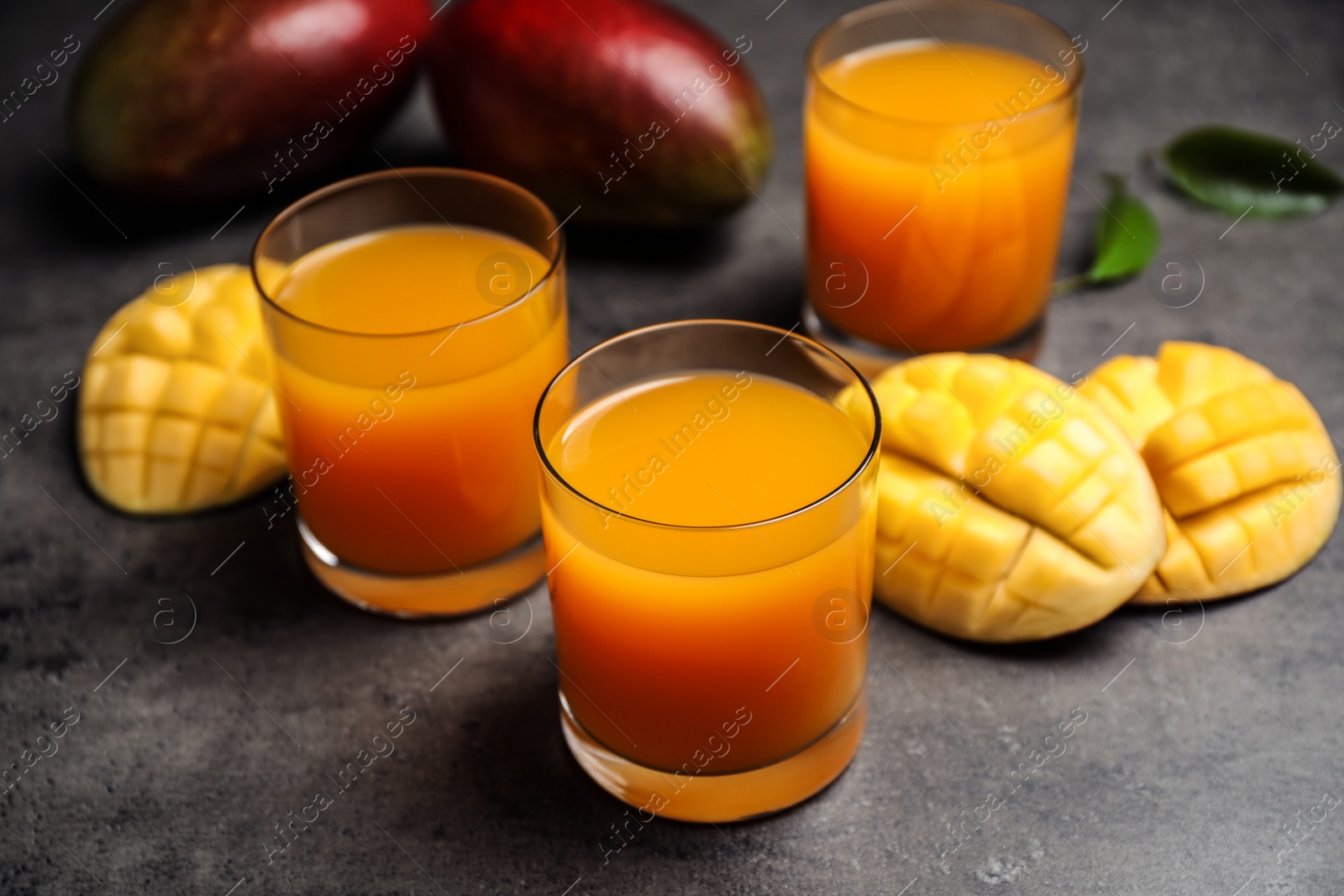 Photo of Fresh delicious mango drink on grey table