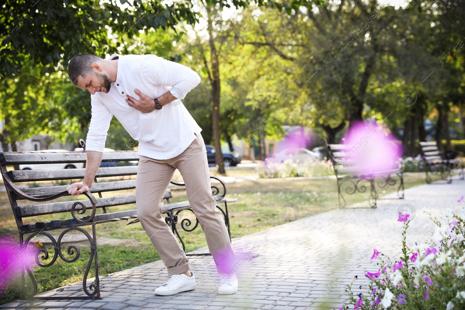 Photo of Man having heart attack near bench in park