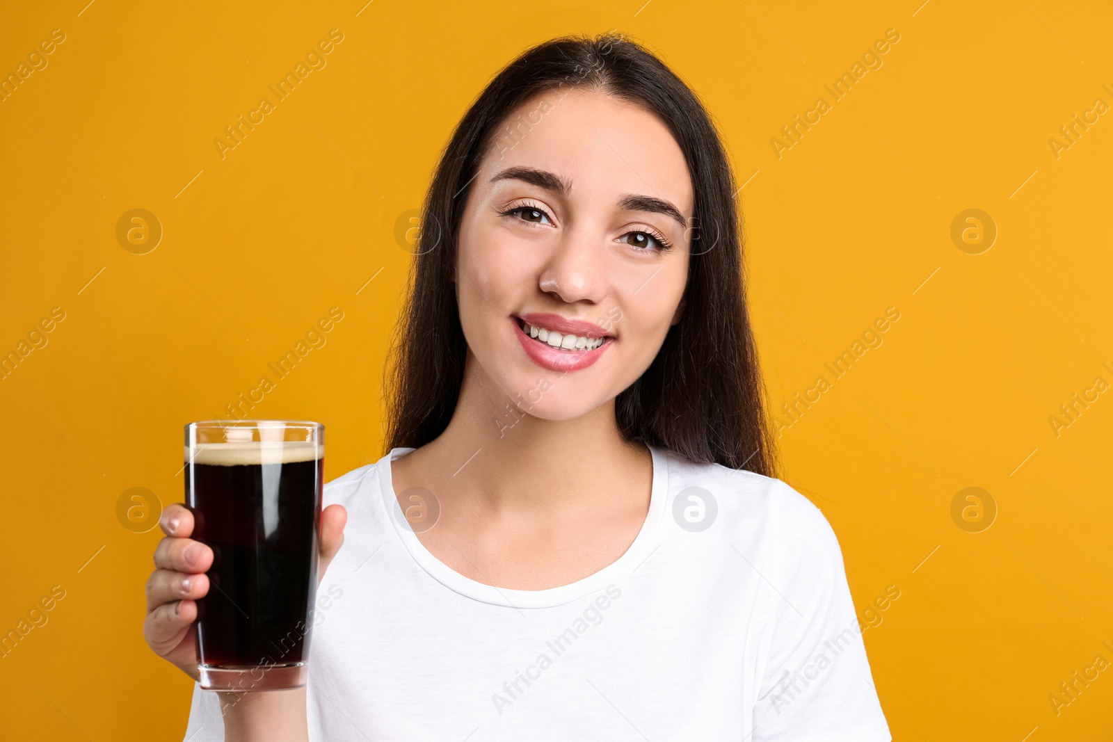 Photo of Beautiful woman with cold kvass on yellow background. Traditional Russian summer drink