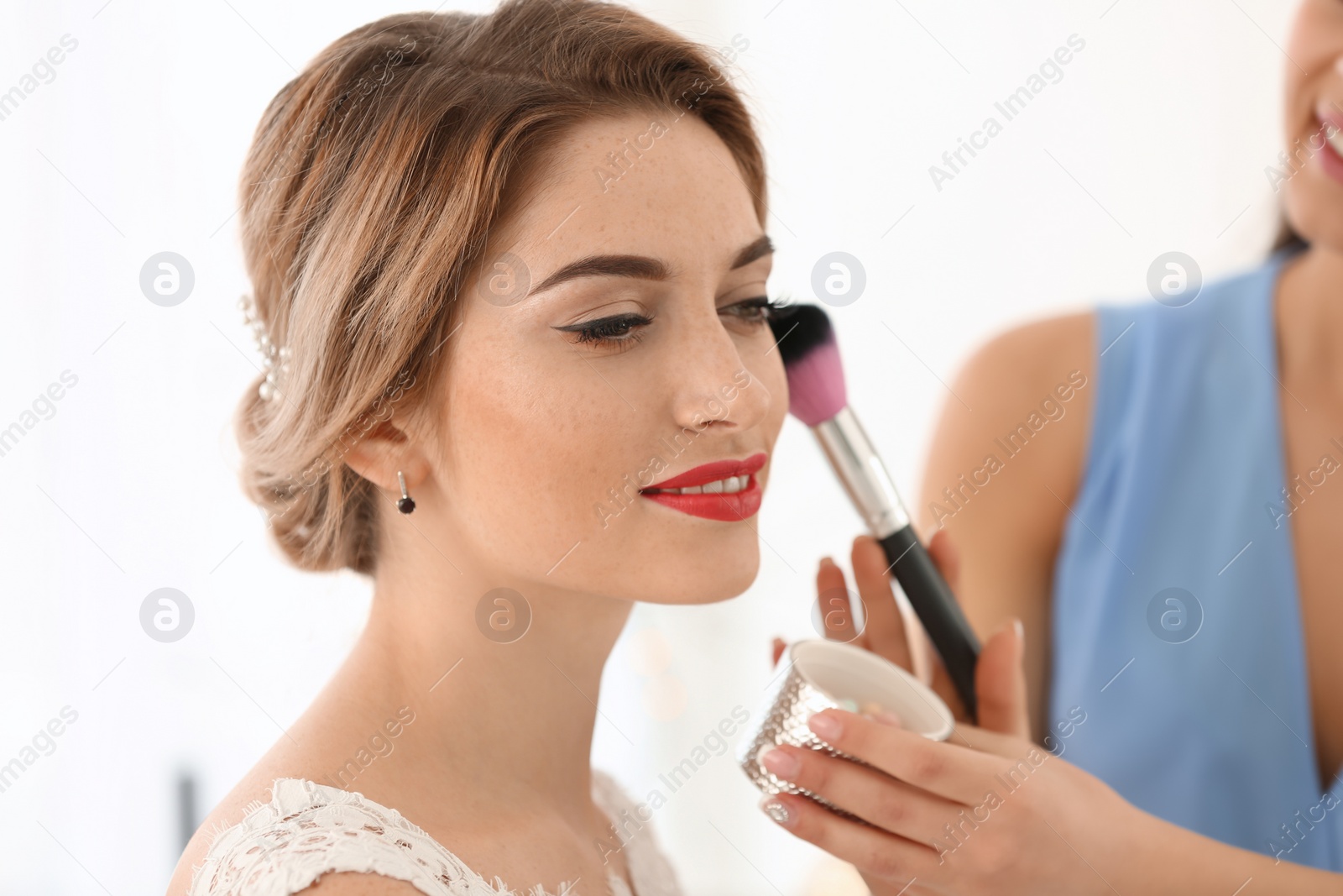 Photo of Makeup artist preparing bride before her wedding