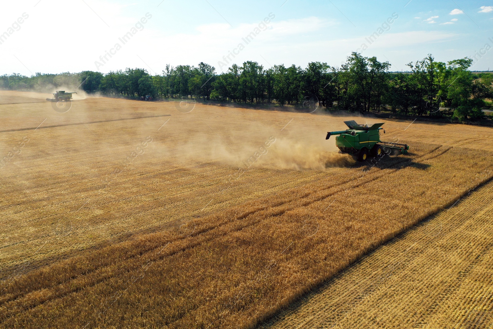 Photo of Modern combine harvester working in field on sunny day. Agriculture industry