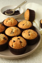 Delicious sweet muffins with chocolate chips on light textured table