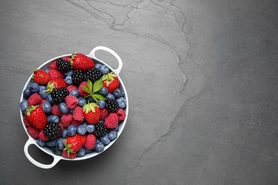 Photo of Mix of ripe berries on grey table, top view. Space for text