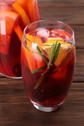 Photo of Glass of delicious sangria on wooden table, closeup