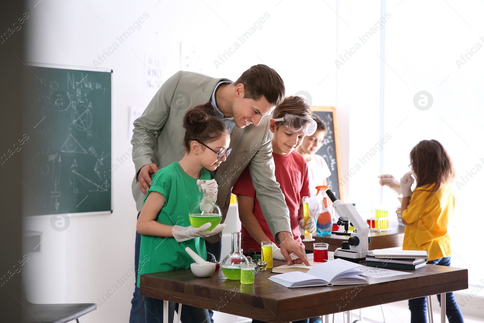 Photo of Teacher with pupils at chemistry lesson in classroom