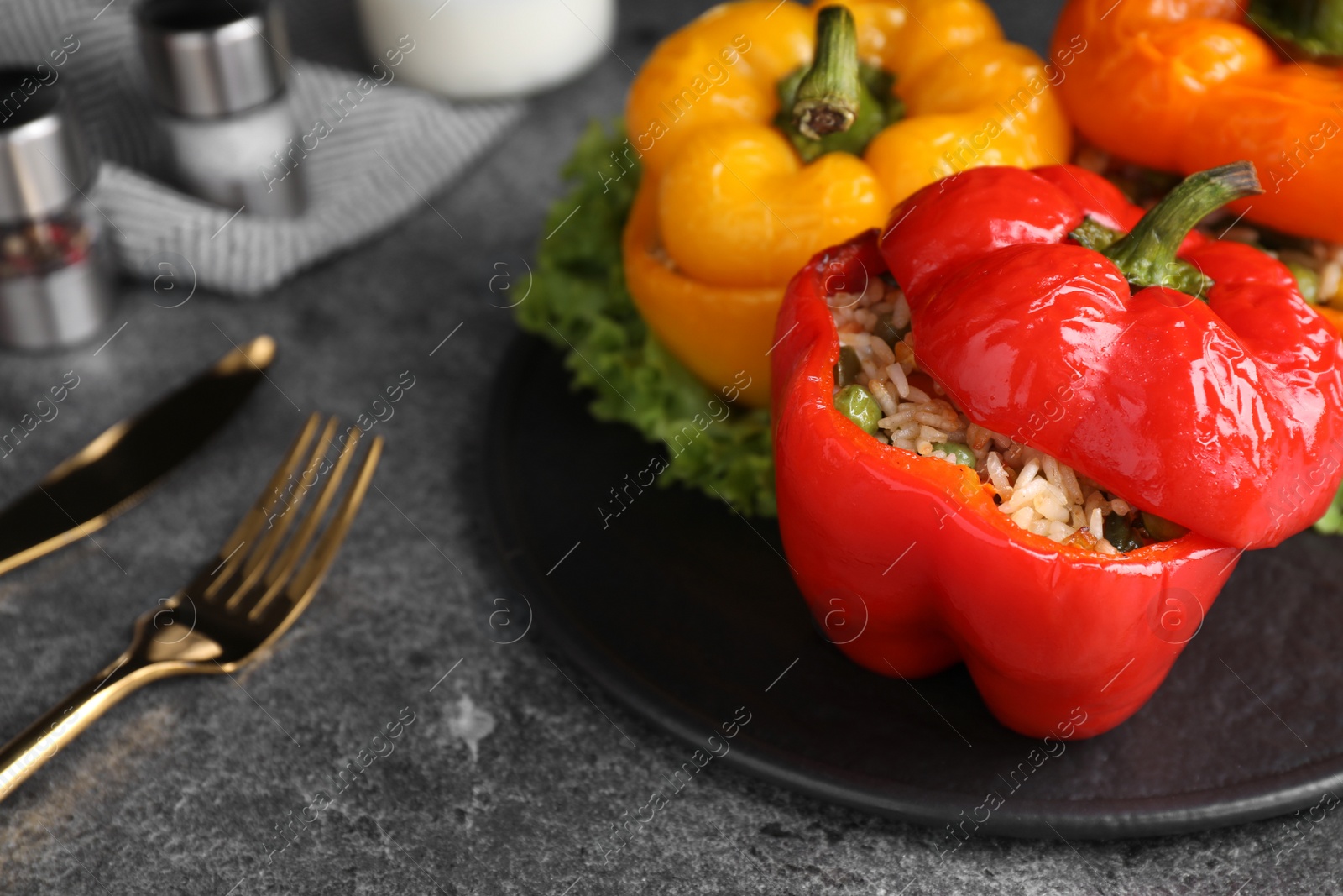 Photo of Tasty stuffed bell peppers on grey table, closeup