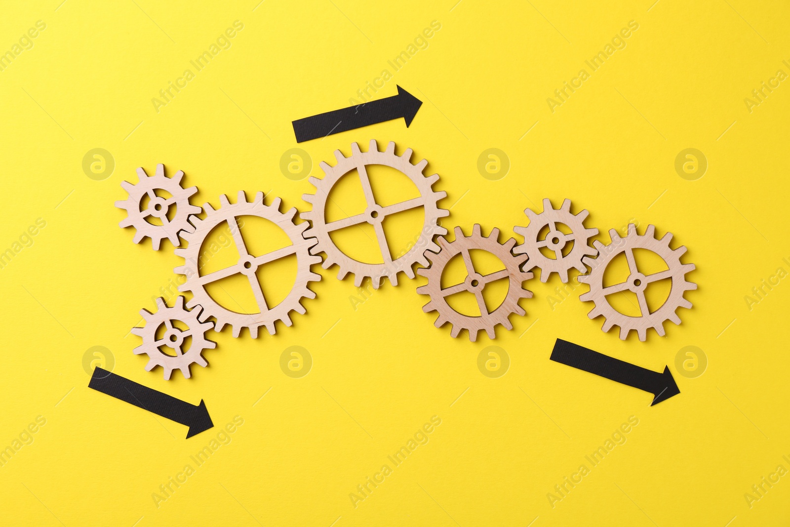 Photo of Business process organization and optimization. Scheme with wooden figures and arrows on yellow background, top view
