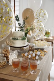 Photo of Beautiful cake and other treats on table in room. Baby shower party