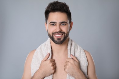Handsome young man with beard after shaving on grey background