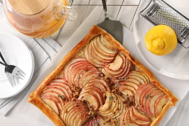 Freshly baked apple pie served on white wooden table, flat lay