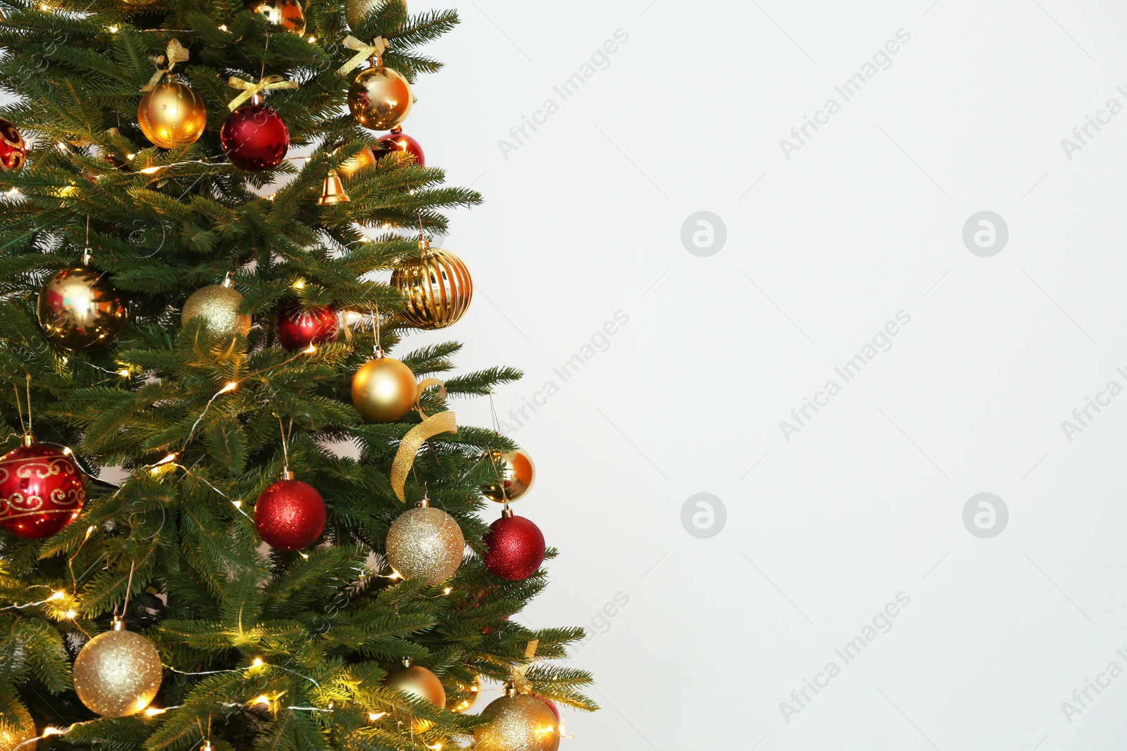 Photo of Beautiful Christmas tree with fairy lights and festive decor on white background