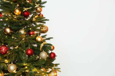 Photo of Beautiful Christmas tree with fairy lights and festive decor on white background