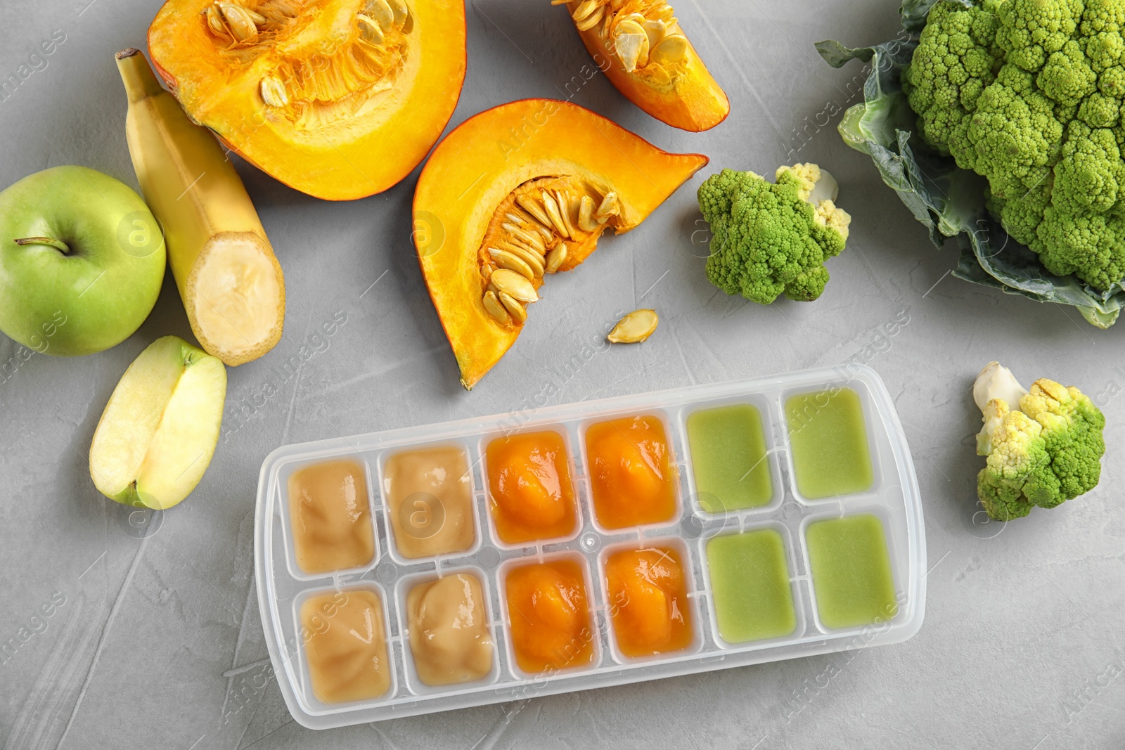 Photo of Flat lay composition with ice cube tray of baby food on gray background