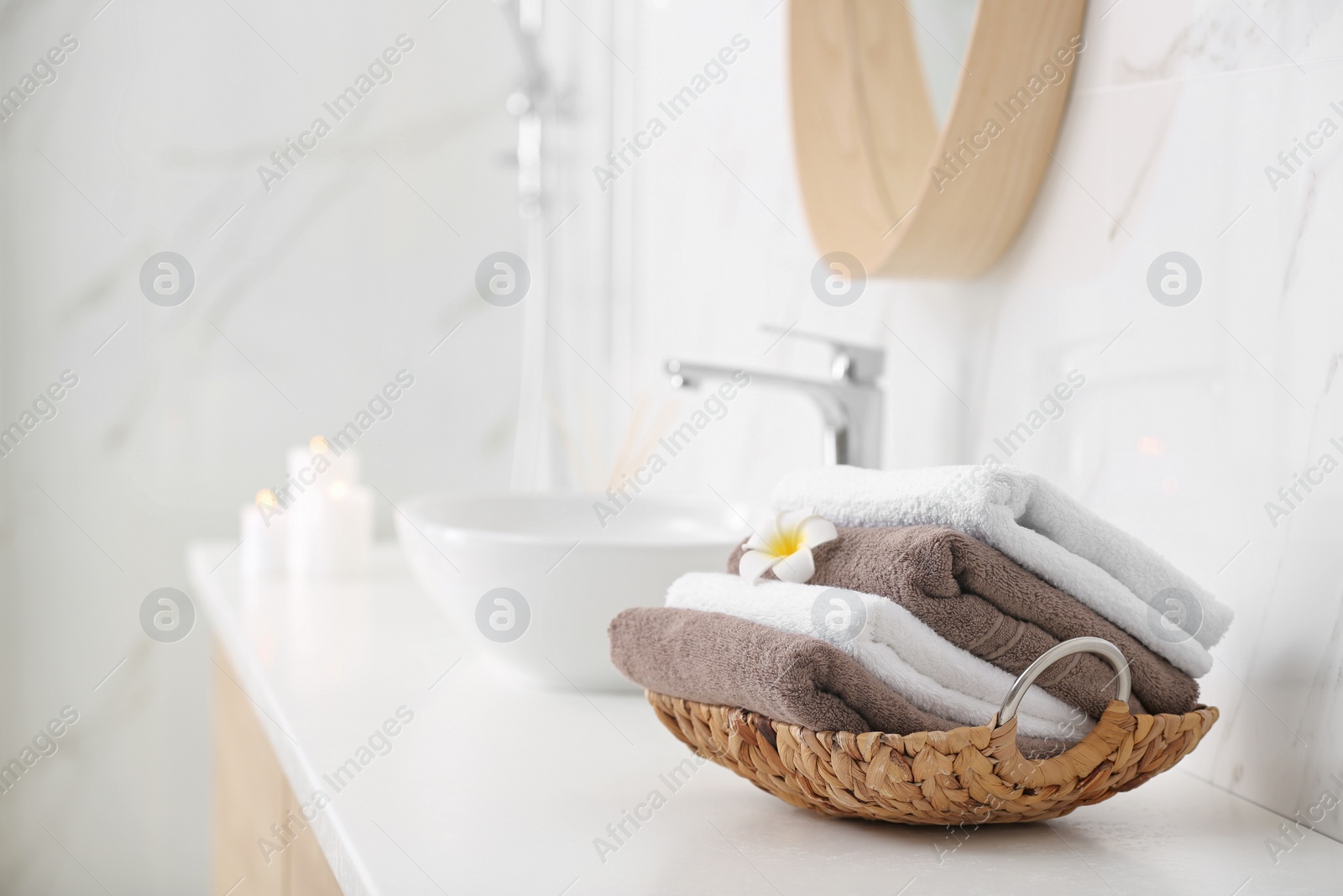 Photo of Basket with clean towels on counter in bathroom. Space for text
