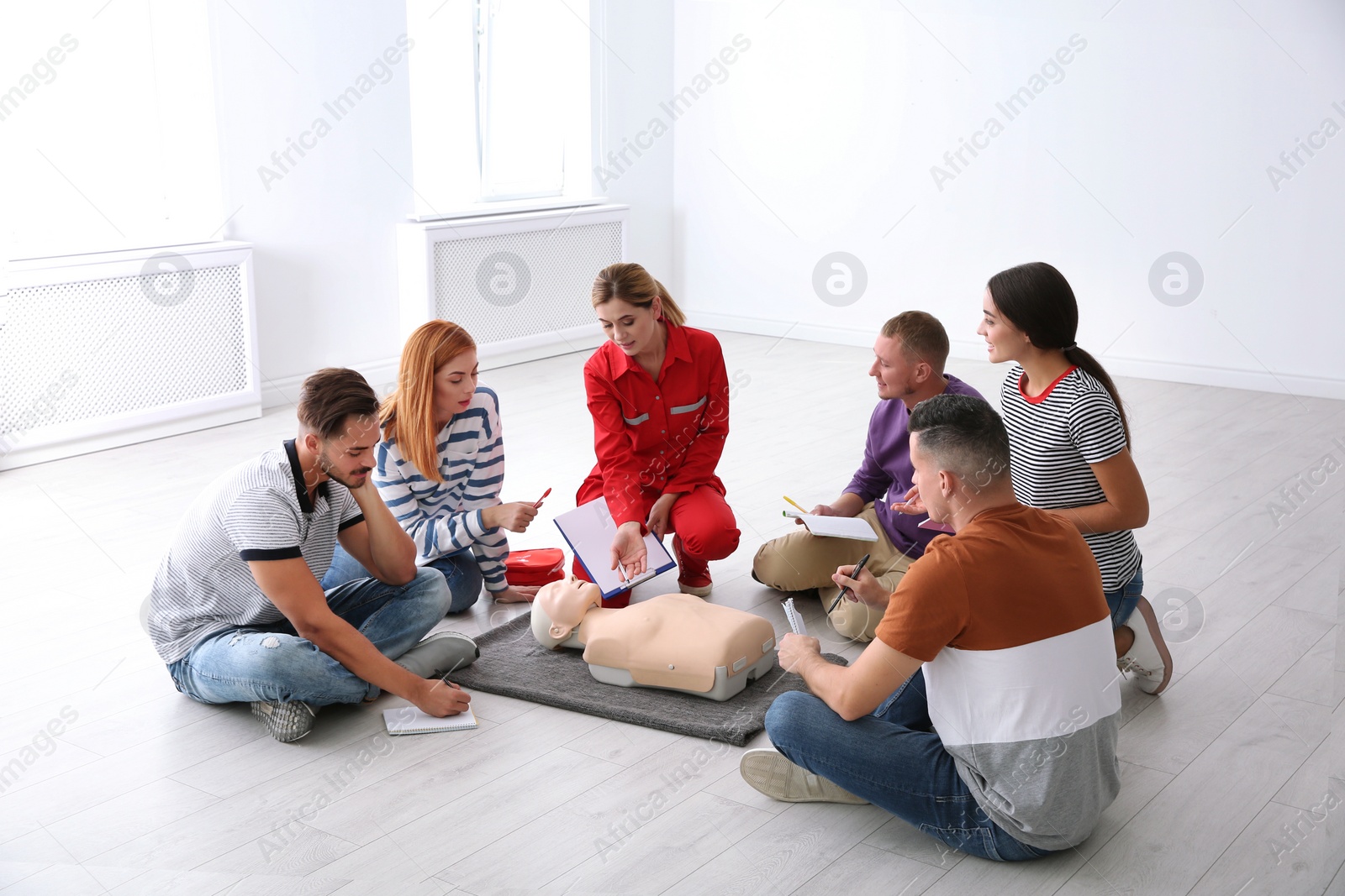 Photo of Group of people with instructor at first aid class indoors