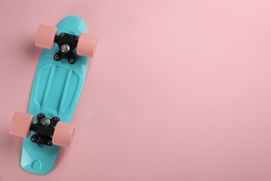 Photo of Skateboard on pink background, top view. Space for text
