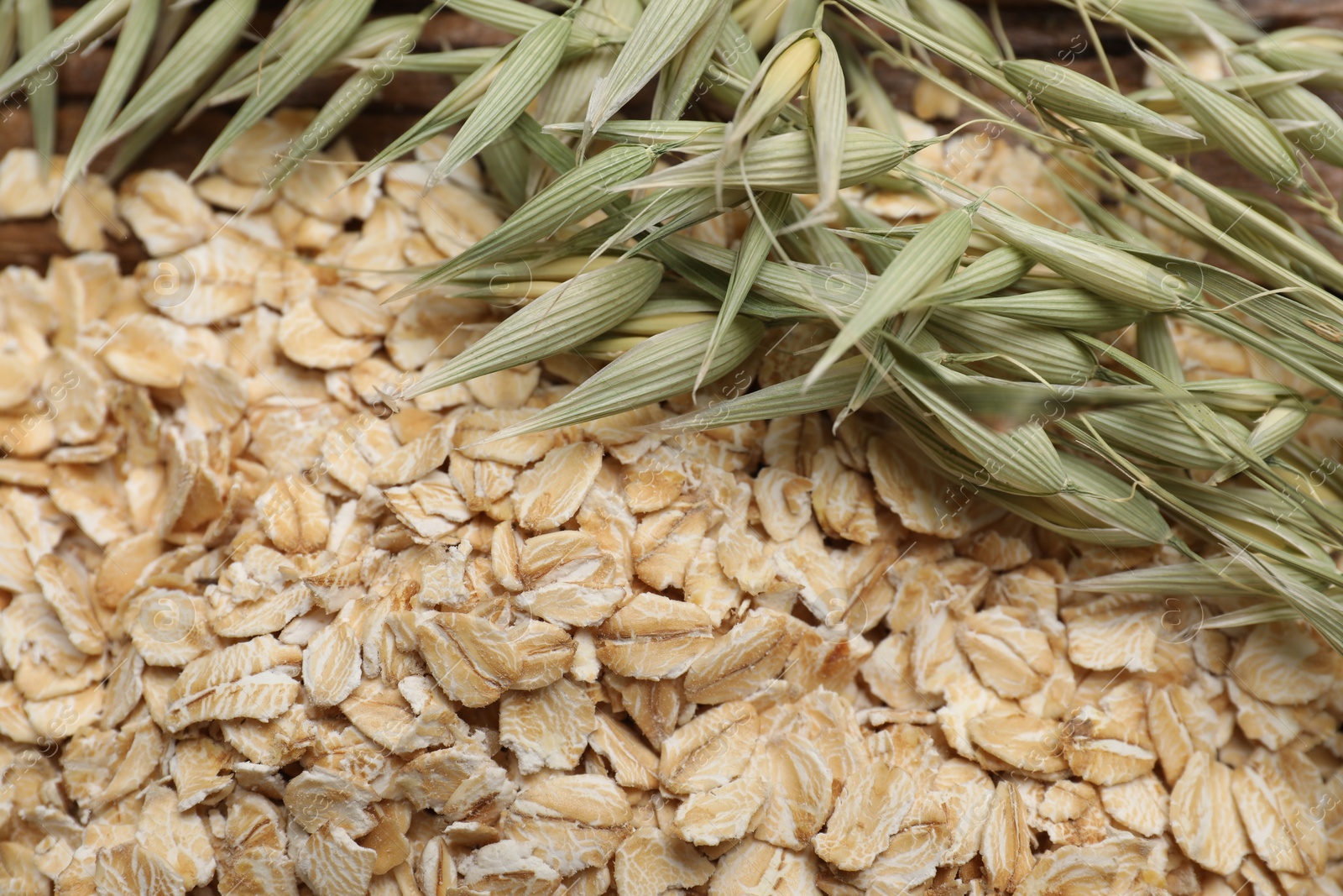 Photo of Oatmeal and branches with florets on table, closeup