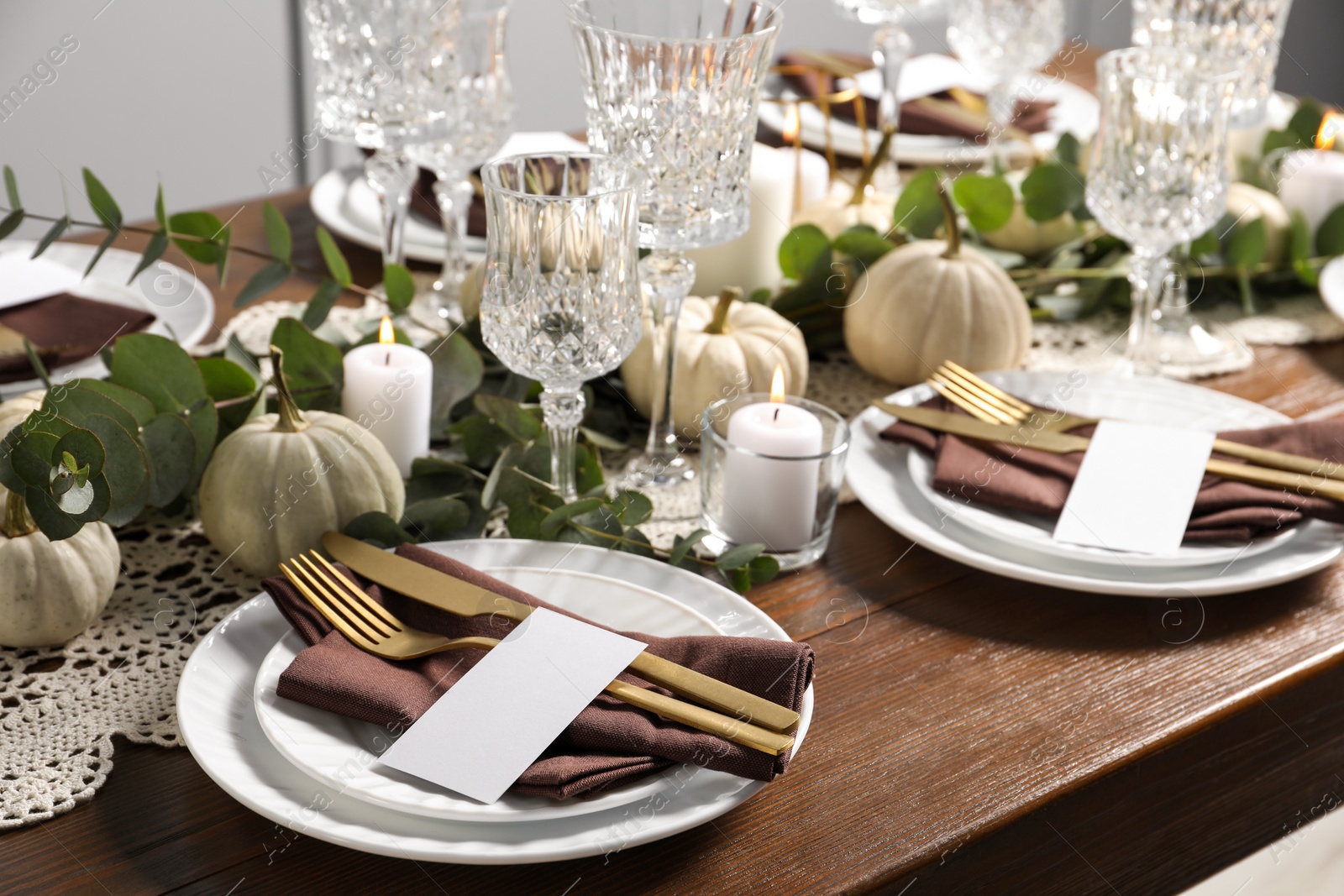 Photo of Beautiful autumn table setting. Plates, cutlery, glasses, blank cards and floral decor