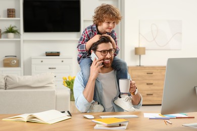 Man working remotely at home. Father with his child at desk
