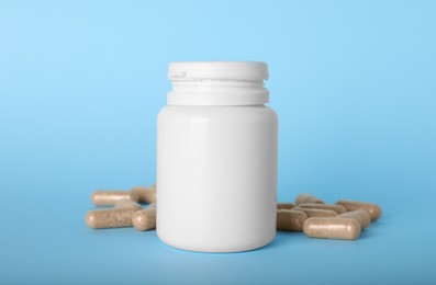 Photo of Gelatin capsules and bottle on light blue background