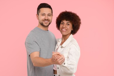 Photo of International dating. Happy couple dancing on pink background