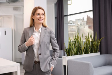 Photo of Female real estate agent indoors. Space for text