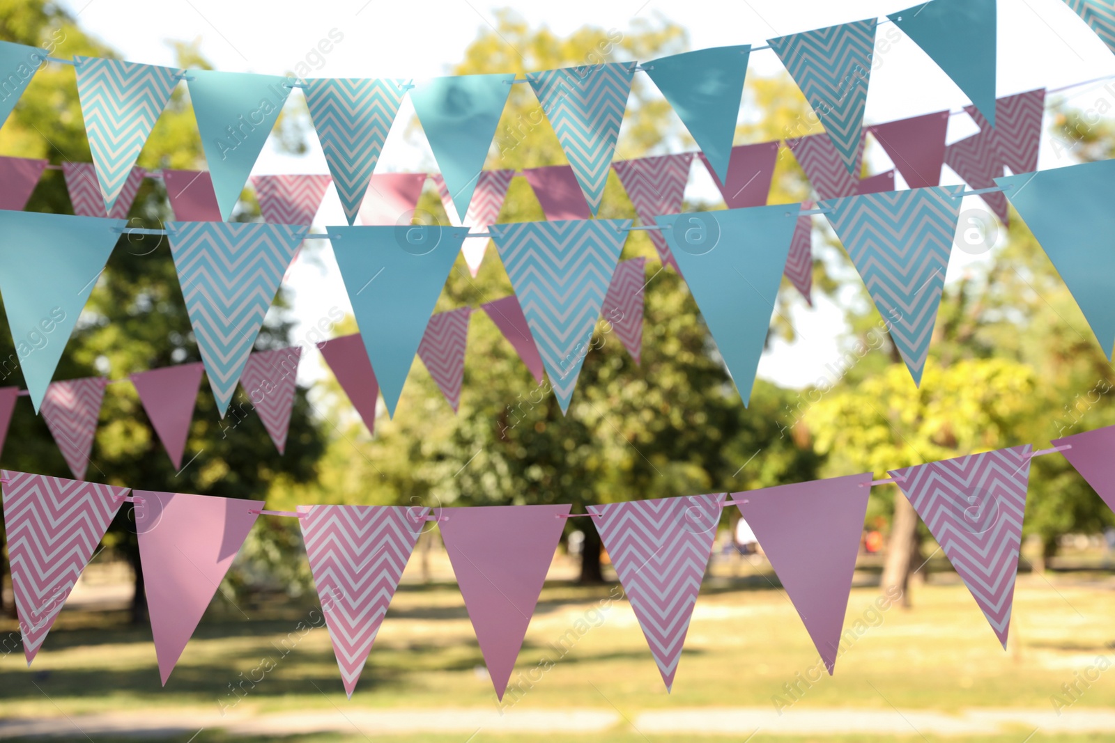 Photo of Colorful bunting flags in park. Party decor