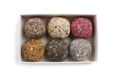 Photo of Different delicious vegan candy balls in box on white background, top view