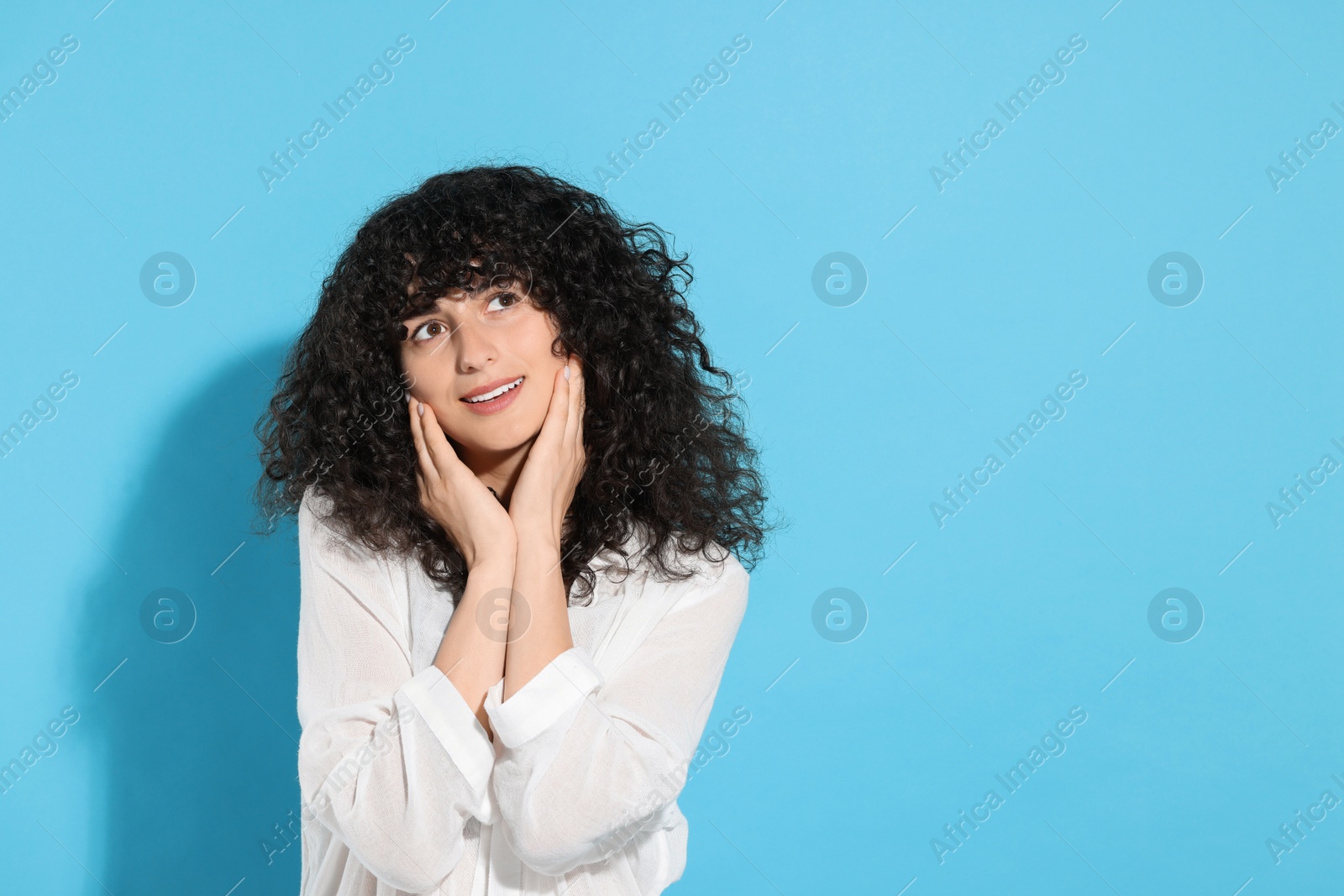 Photo of Portrait of beautiful young woman on light blue background, space for text