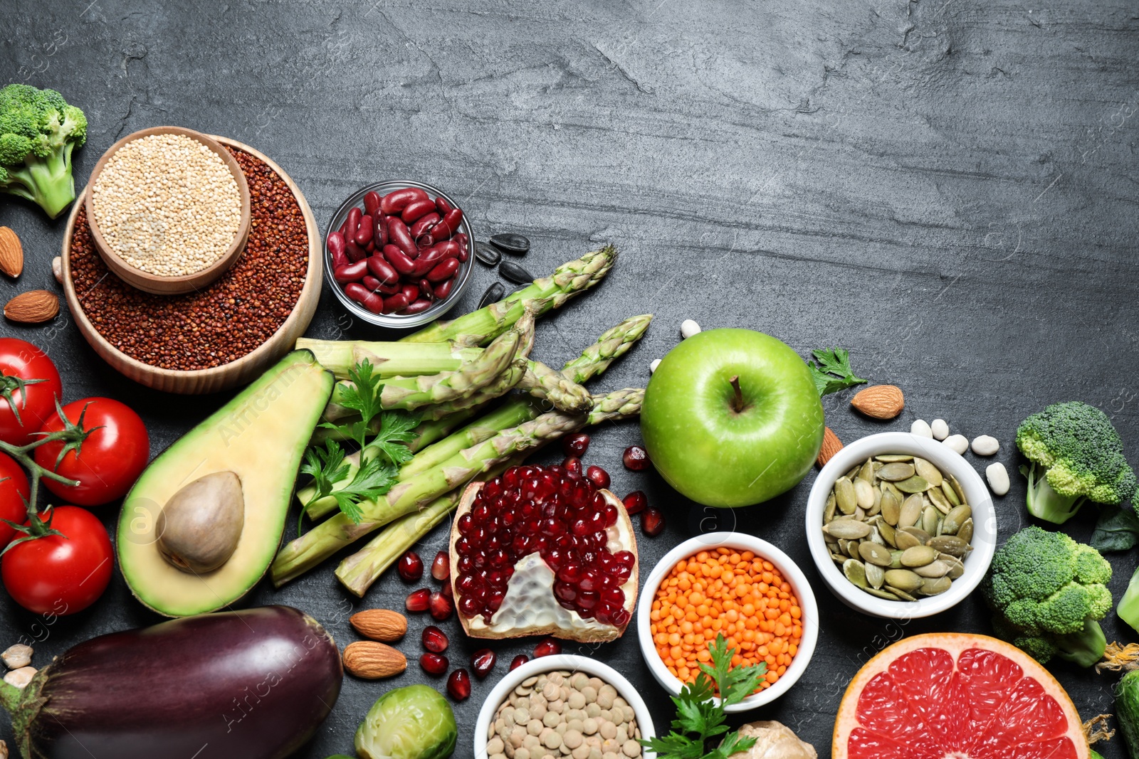 Photo of Fresh vegetables, fruits and seeds on black table, flat lay