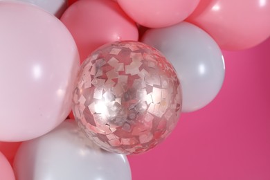 Beautiful colorful balloons on pink background, closeup